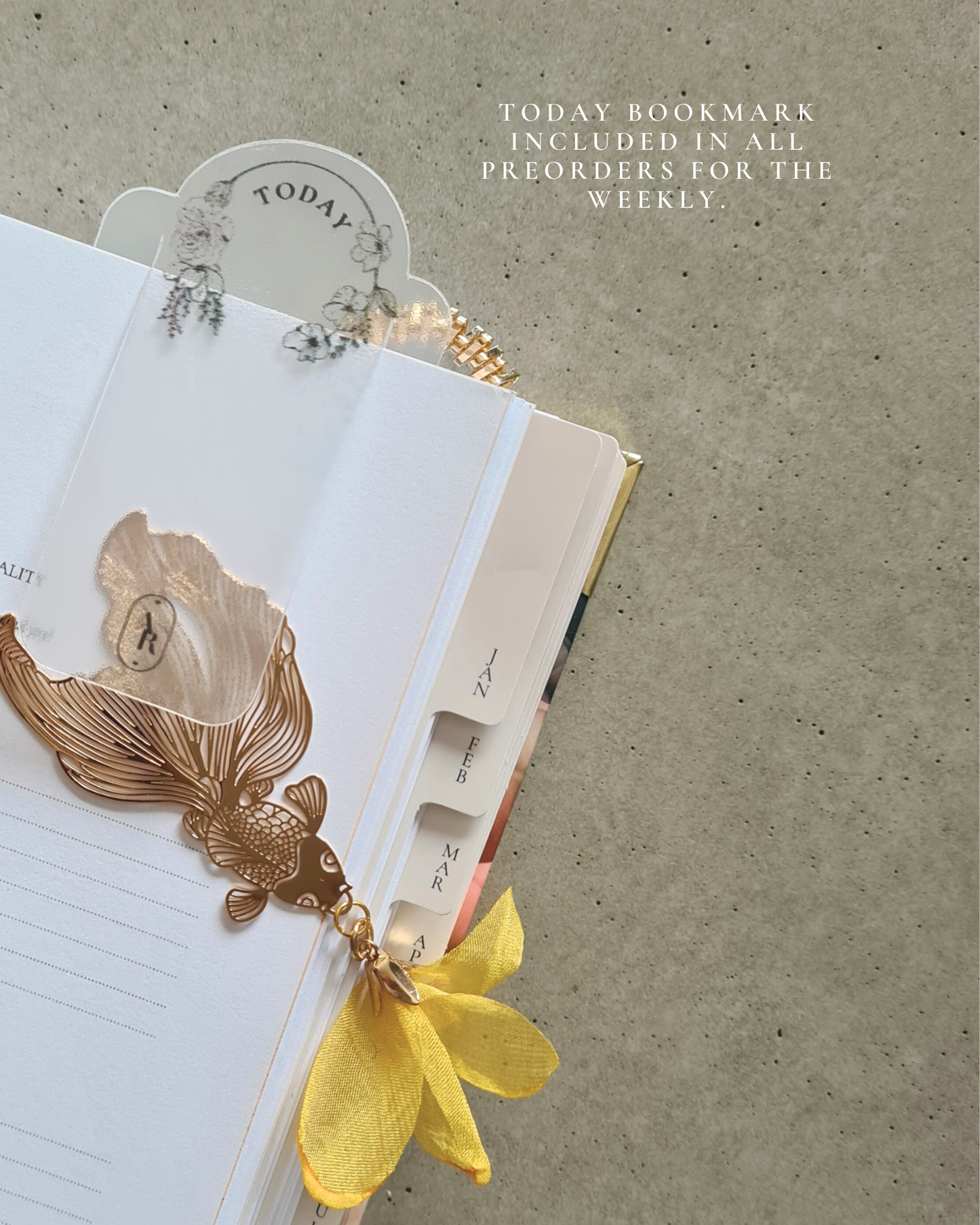 Decorative bookmark with a yellow ribbon on an open book, placed on a textured surface.